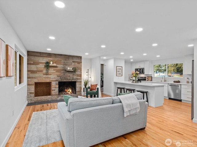 8421 240th St SW, Edmonds, WA 98020 - living room featuring a fireplace, recessed lighting, light wood finished floors, and baseboards