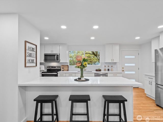 8421 240th St SW, Edmonds, WA 98020 - kitchen with appliances with stainless steel finishes, tasteful backsplash, white cabinetry, a kitchen bar, and recessed lighting