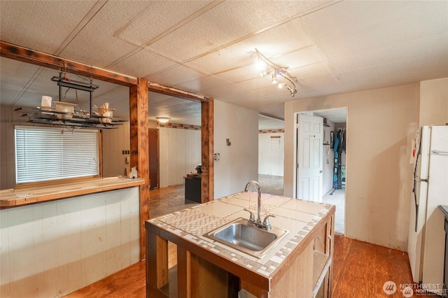 7503 189th Street Ct E Unit 12, Puyallup, WA 98375 - kitchen with wood finished floors, wood walls, freestanding refrigerator, and tile counters