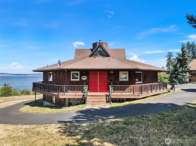 10601 87th Ct, Anderson Island, WA 98303 - view of front of house with a chimney, a water view, and a shingled roof
