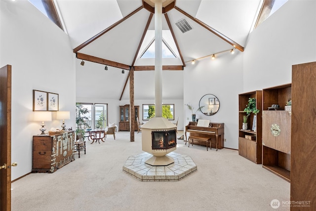 10601 87th Ct, Anderson Island, WA 98303 - carpeted living area with high vaulted ceiling, a wood stove, beamed ceiling, and a ceiling fan