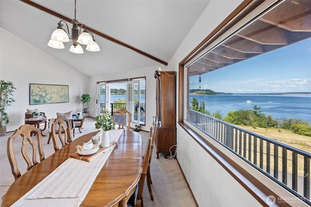 10601 87th Ct, Anderson Island, WA 98303 - dining space featuring light carpet, a chandelier, a water view, and high vaulted ceiling