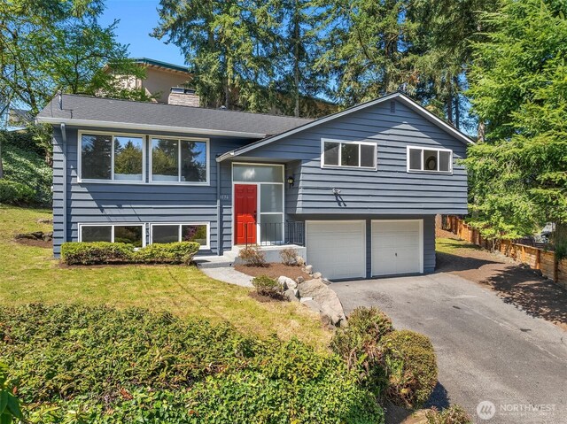 1136 N 146th Pl, Shoreline, WA 98133 - split foyer home with asphalt driveway, a chimney, a garage, and a shingled roof