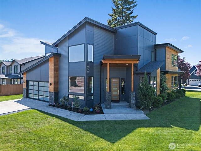 10501 Angeline Rd E, Bonney Lake, WA 98391 - contemporary house featuring concrete driveway, a garage, and stone siding