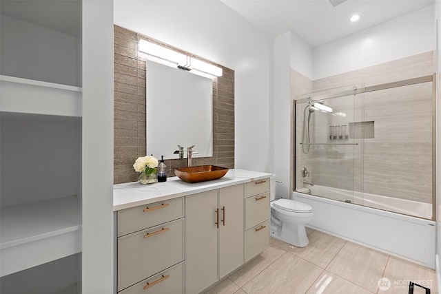 10501 Angeline Rd E, Bonney Lake, WA 98391 - bathroom with toilet, vanity, combined bath / shower with glass door, backsplash, and tile patterned flooring