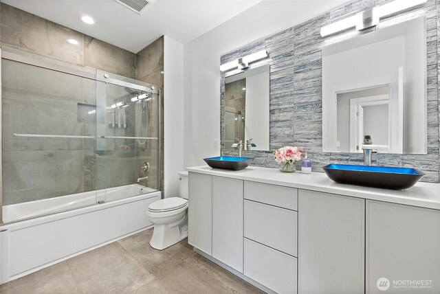 10501 Angeline Rd E, Bonney Lake, WA 98391 - bathroom featuring enclosed tub / shower combo, toilet, double vanity, tasteful backsplash, and tile patterned floors