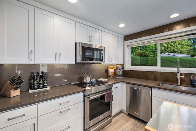 7008 155th Pl NE, Redmond, WA 98052 - kitchen with appliances with stainless steel finishes, white cabinets, decorative backsplash, and recessed lighting