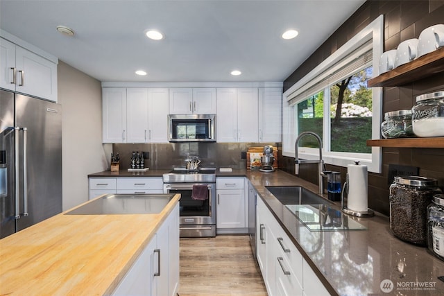 7008 155th Pl NE, Redmond, WA 98052 - kitchen with stainless steel appliances, white cabinetry, recessed lighting, tasteful backsplash, and butcher block countertops