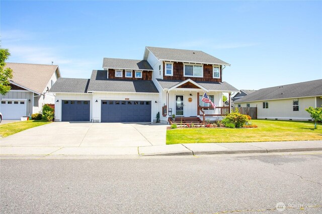 7328 Seashell Way, Blaine, WA 98230 - view of front of house featuring board and batten siding, a porch, a garage, concrete driveway, and a front lawn