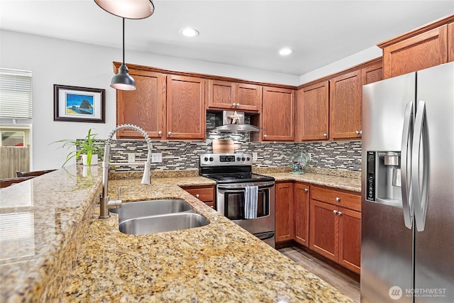 7328 Seashell Way, Blaine, WA 98230 - kitchen featuring stainless steel appliances, a sink, wood finished floors, light stone counters, and decorative backsplash