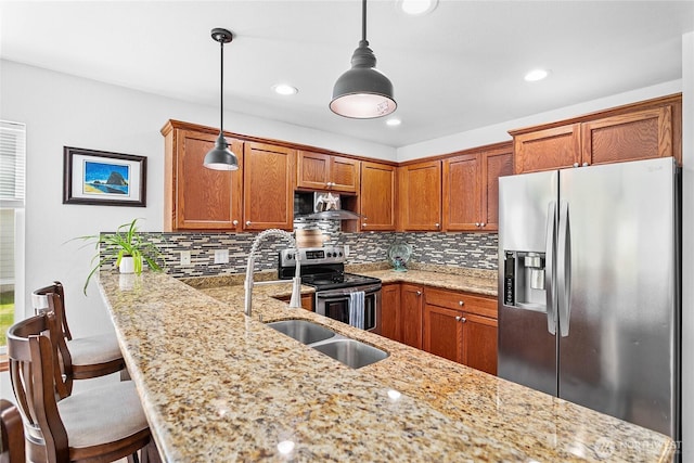 7328 Seashell Way, Blaine, WA 98230 - kitchen with stainless steel appliances, brown cabinetry, decorative backsplash, a sink, and recessed lighting