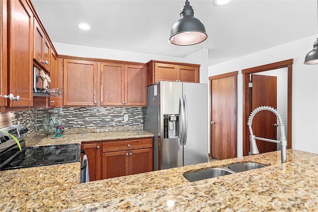 7328 Seashell Way, Blaine, WA 98230 - kitchen featuring appliances with stainless steel finishes, decorative backsplash, light stone counters, brown cabinetry, and recessed lighting
