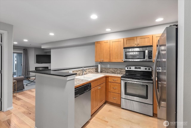 3318 30th Ave SW Unit B402, Seattle, WA 98126 - kitchen featuring stainless steel appliances, a sink, a peninsula, light wood-style flooring, and recessed lighting