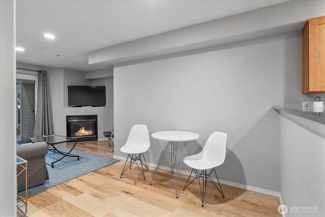 3318 30th Ave SW Unit B402, Seattle, WA 98126 - dining area with wood finished floors, a glass covered fireplace, recessed lighting, and baseboards
