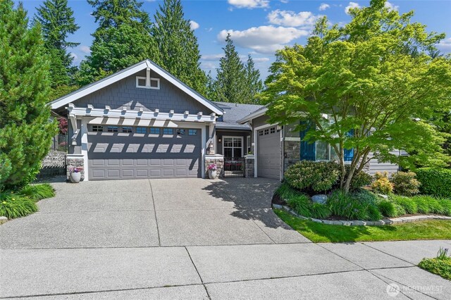 13310 239th Way NE, Redmond, WA 98053 - view of front of house featuring stone siding, a garage, and concrete driveway