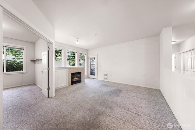 15026 40th Ave W Unit 13-104, Lynnwood, WA 98087 - unfurnished living room with healthy amount of natural light, carpet flooring, and a tiled fireplace