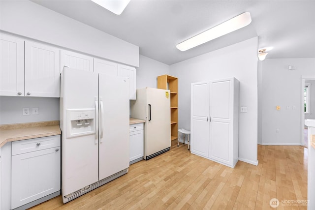 15026 40th Ave W Unit 13-104, Lynnwood, WA 98087 - kitchen featuring white fridge with ice dispenser, freestanding refrigerator, light countertops, and white cabinetry