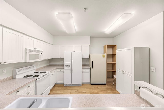 15026 40th Ave W Unit 13-104, Lynnwood, WA 98087 - kitchen with white appliances, light wood-type flooring, light countertops, and white cabinets