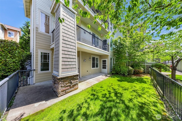 15026 40th Ave W Unit 13-104, Lynnwood, WA 98087 - rear view of property featuring a balcony, a fenced backyard, and a patio area