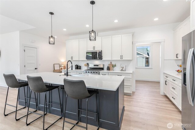 120 Sable Dr, Everson, WA 98247 - kitchen with stainless steel appliances, decorative backsplash, light wood finished floors, white cabinets, and recessed lighting