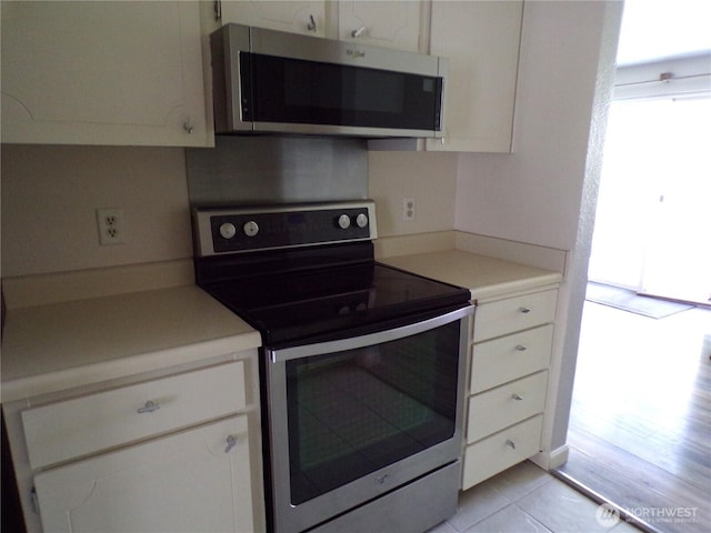 2020 SW 318th Pl Unit C3, Federal Way, WA 98023 - kitchen with appliances with stainless steel finishes, white cabinetry, light countertops, and light tile patterned flooring