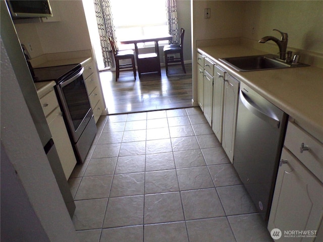 2020 SW 318th Pl Unit C3, Federal Way, WA 98023 - kitchen with appliances with stainless steel finishes, a sink, light countertops, light tile patterned flooring, and white cabinets