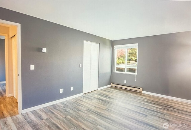 2020 SW 318th Pl Unit C3, Federal Way, WA 98023 - unfurnished bedroom with a baseboard radiator, wood finished floors, baseboards, and a closet