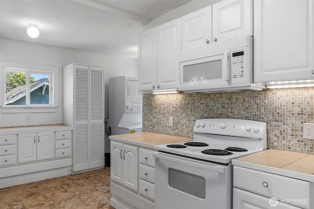 212 N Michigan St, Aberdeen, WA 98520 - kitchen with white appliances, stacked washer / dryer, backsplash, white cabinets, and light countertops