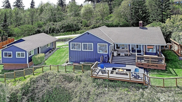 987 Cavalero Rd, Camano Island, WA 98282 - rear view of house with board and batten siding, a deck, a chimney, and an outdoor living space