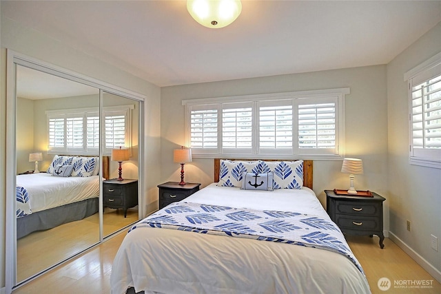 987 Cavalero Rd, Camano Island, WA 98282 - bedroom with multiple windows, light wood-style floors, a closet, and baseboards