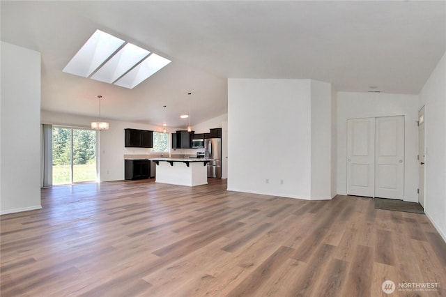 250 Hewitt Rd Unit 23, Chehalis, WA 98532 - unfurnished living room with a skylight, lofted ceiling, a chandelier, light wood-style flooring, and baseboards