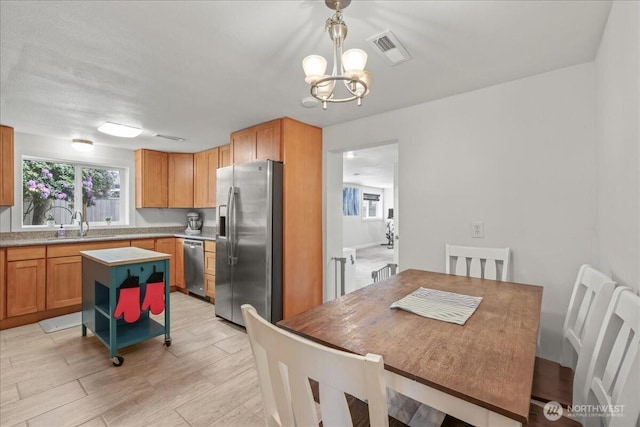 1412 Mcmillan Ave, Sumner, WA 98390 - dining room with a chandelier, plenty of natural light, and light wood-style flooring