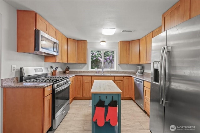 1412 Mcmillan Ave, Sumner, WA 98390 - kitchen featuring stainless steel appliances, a sink, and a center island