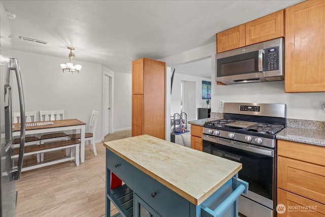 1412 Mcmillan Ave, Sumner, WA 98390 - kitchen featuring stainless steel appliances, a chandelier, a kitchen island, hanging light fixtures, and butcher block counters