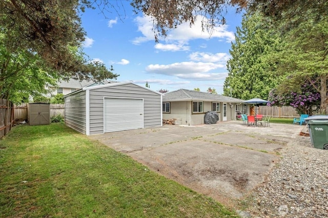 1412 Mcmillan Ave, Sumner, WA 98390 - rear view of house with driveway, a garage, and a patio area
