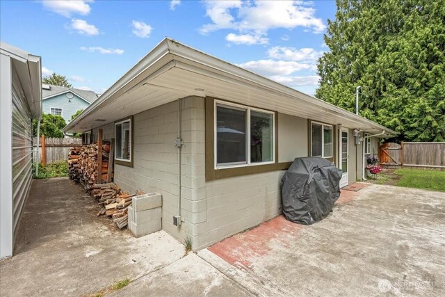 1412 Mcmillan Ave, Sumner, WA 98390 - view of property exterior with a patio and concrete block siding