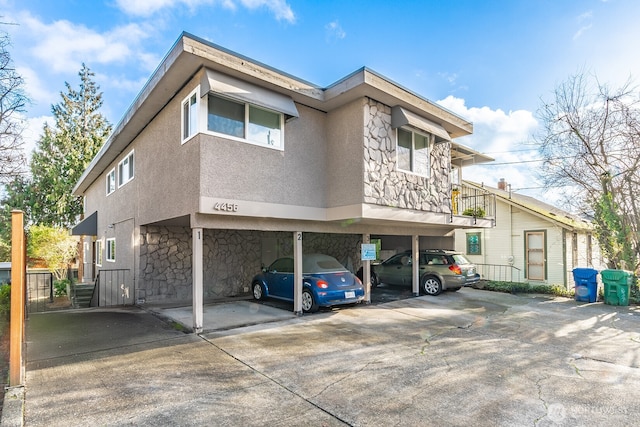 4456 Whitman Ave N, Seattle, WA 98103 - view of front of house with stone siding, covered parking, and stucco siding