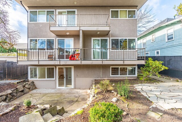 4456 Whitman Ave N, Seattle, WA 98103 - back of house featuring a balcony, stucco siding, and a patio area