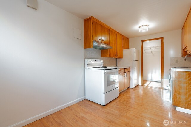 4456 Whitman Ave N, Seattle, WA 98103 - kitchen featuring white appliances, under cabinet range hood, light countertops, and light wood finished floors