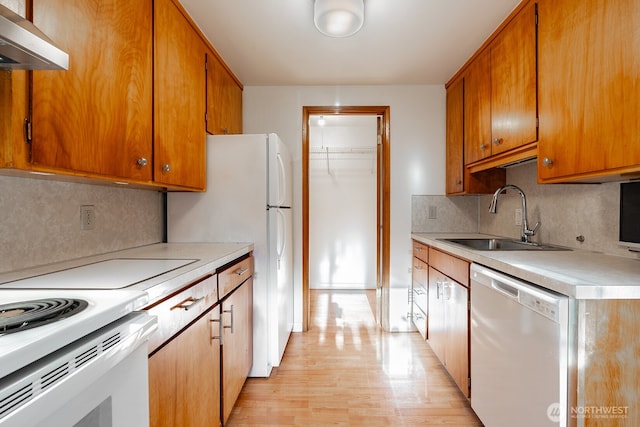 4456 Whitman Ave N, Seattle, WA 98103 - kitchen featuring white appliances, wall chimney range hood, a sink, light countertops, and light wood finished floors