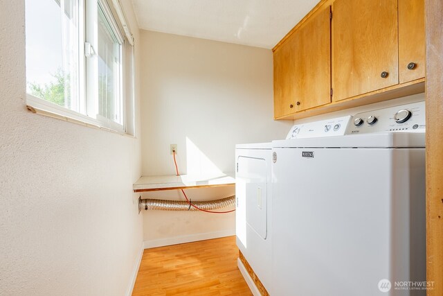4456 Whitman Ave N, Seattle, WA 98103 - washroom with cabinet space, light wood-style flooring, baseboards, and separate washer and dryer