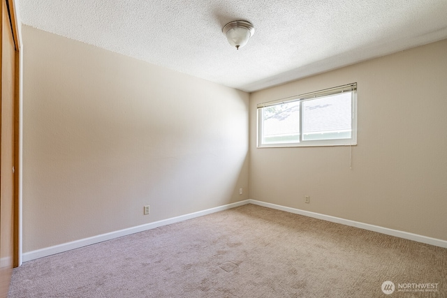 4456 Whitman Ave N, Seattle, WA 98103 - empty room featuring a textured ceiling, carpet floors, and baseboards