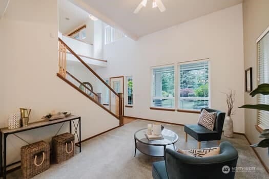 1155 Woods Rd SE, Port Orchard, WA 98366 - carpeted living area featuring stairway, a towering ceiling, and ceiling fan