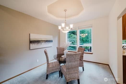 1155 Woods Rd SE, Port Orchard, WA 98366 - carpeted dining area with a chandelier and a raised ceiling