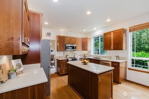 1155 Woods Rd SE, Port Orchard, WA 98366 - kitchen featuring stainless steel appliances, light wood finished floors, light countertops, brown cabinetry, and recessed lighting
