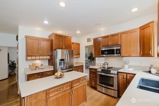 1155 Woods Rd SE, Port Orchard, WA 98366 - kitchen with stainless steel appliances, light countertops, a center island, light wood finished floors, and recessed lighting