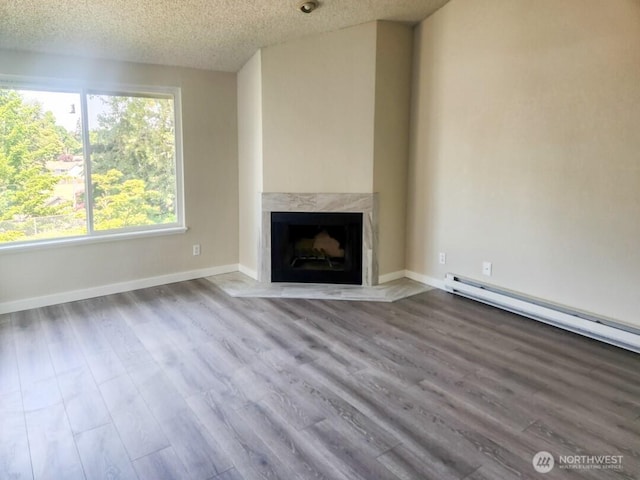 2611 NE 4th St Unit 234, Renton, WA 98056 - unfurnished living room featuring a fireplace, a textured ceiling, wood finished floors, and baseboards