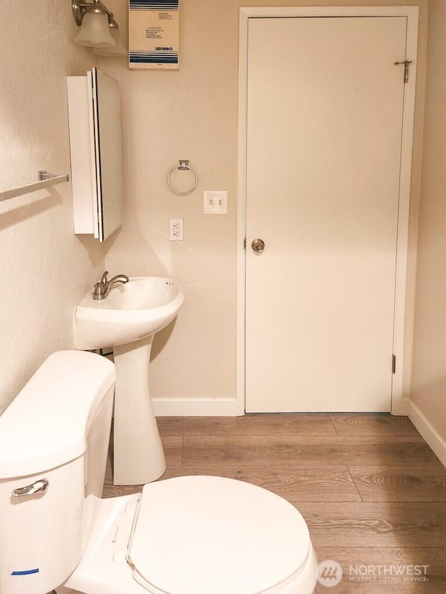 2611 NE 4th St Unit 234, Renton, WA 98056 - bathroom featuring toilet, wood finished floors, and baseboards