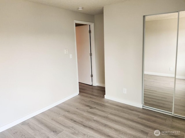 2611 NE 4th St Unit 234, Renton, WA 98056 - unfurnished bedroom with a closet, wood finished floors, and baseboards