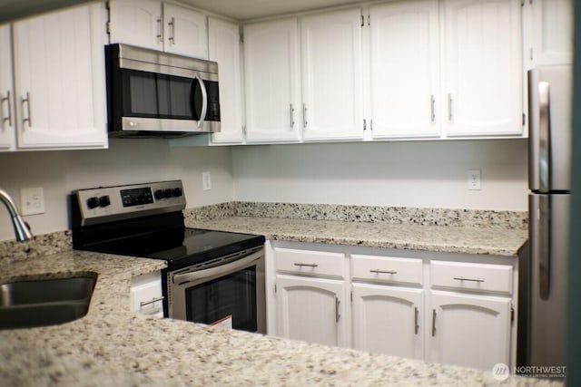 2611 NE 4th St Unit 234, Renton, WA 98056 - kitchen with appliances with stainless steel finishes, a sink, and white cabinets